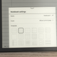 A close-up of the on-screen template options for the Kindle Scribe's notebooks, with the device sitting on a wooden table.